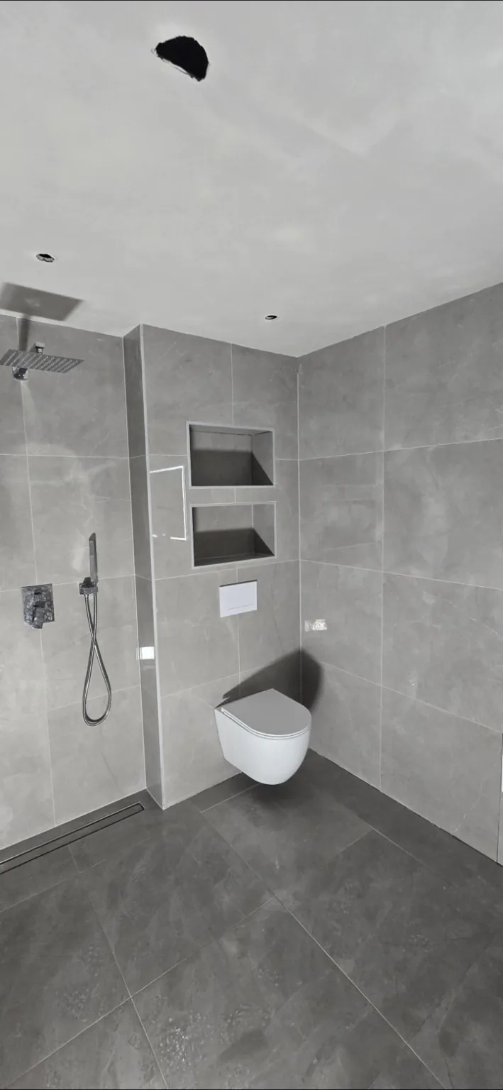 Salle de bain rénovée avec douche italienne et WC suspendu